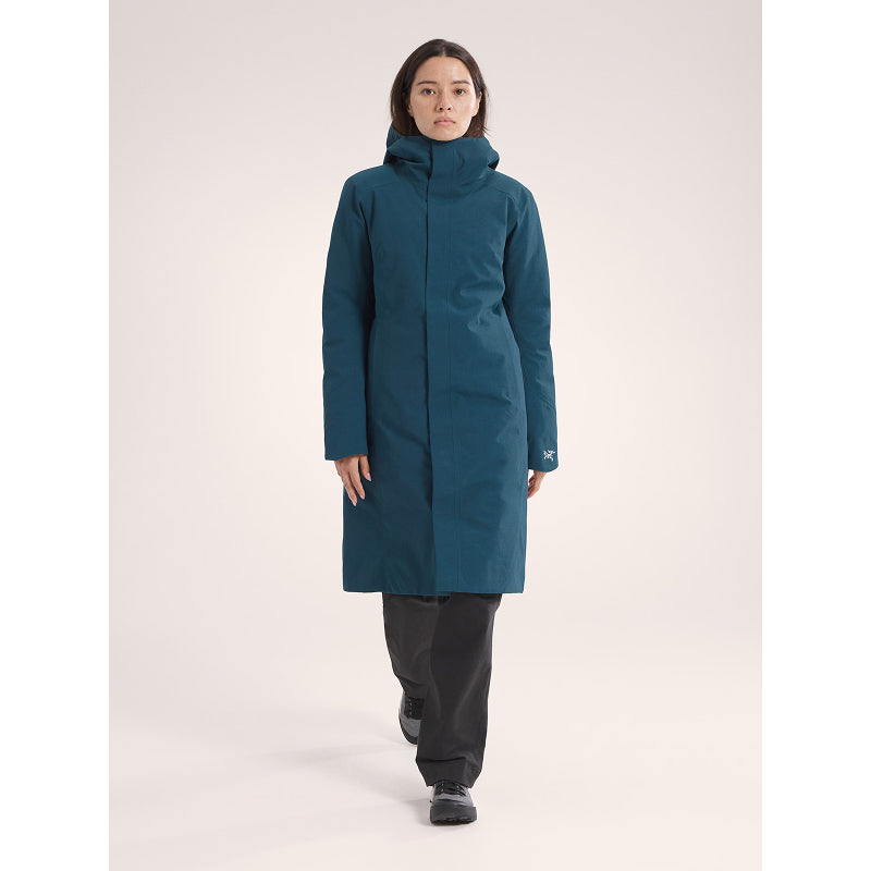 Person wearing a teal coat on a white background