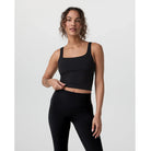 Woman wearing a black athletic outfit on a white background