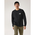 Person wearing a black long-sleeve shirt with a logo on a plain background Arc’teryx