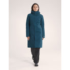 Person wearing a teal coat on a white background